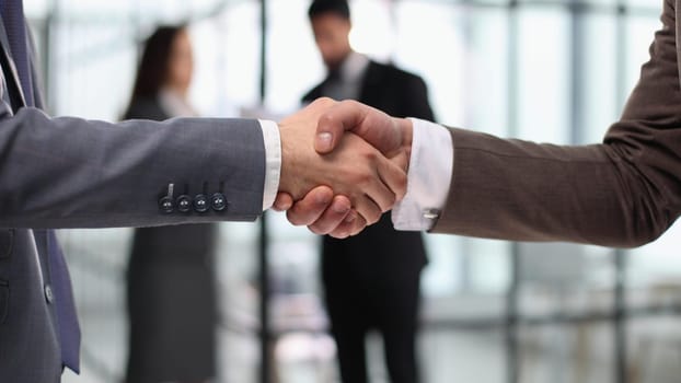 Close-up of business partners handshaking after successful agreement