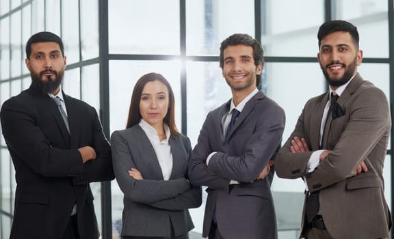 Portrait, collaboration and diversity with a business team standing arms crossed together in their office.