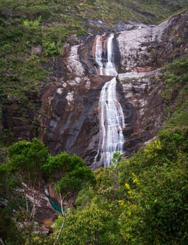 Witness the breathtaking beauty of Caparao's cascading waterfall, as it falls from great heights onto solid rock, surrounded by lush greenery - a nature lover's paradise.