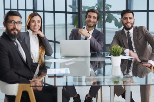 Office days. Group of business people sitting together at a table and looking at the camera