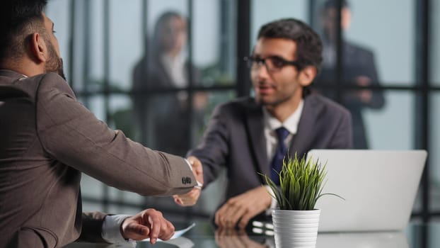 Colleagues chatting, sitting together at office table