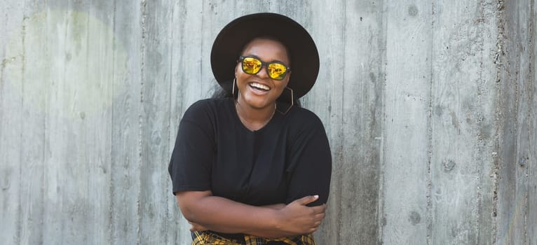 Close-up portrait of stylish young African American girl with curly hair in fashionable round sunglasses. Summer hipster photos with instagram style