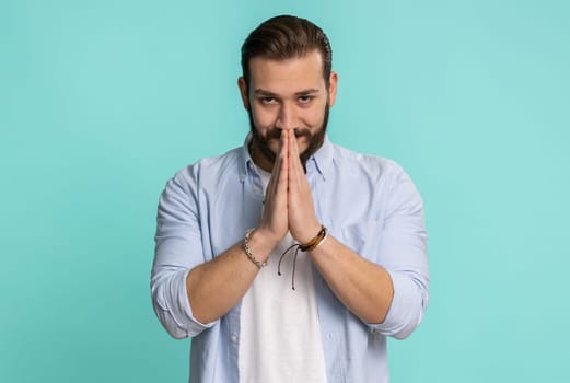 Sneaky cunning lebanese bearded man with tricky face gesticulating and scheming evil plan, thinking over devious villain idea, cunning cheats, jokes, pranks. Arabian guy isolated on blue background