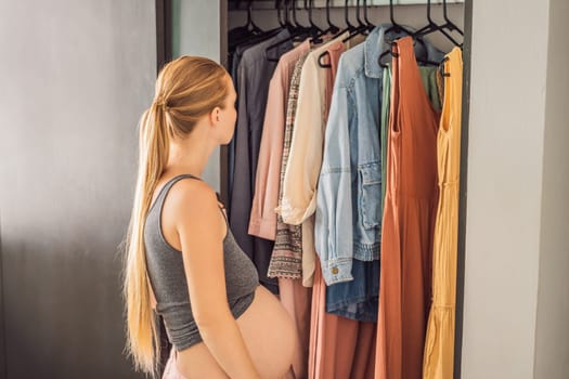 A pregnant woman has nothing to wear. A pregnant woman stands in front of a closet with clothes and does not know what to wear because the clothes do not fit on her.