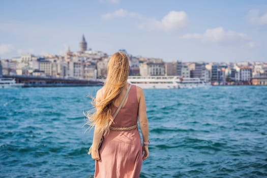 Portrait of beautiful woman tourist with view of Galata tower in Beyoglu, Istanbul, Turkey. Turkiye.