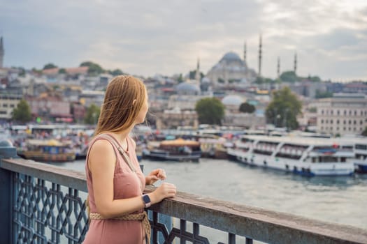 Young tourist woman on Galata bridge, Golden Horn bay, Istanbul. Panorama cityscape of famous tourist destination Bosphorus strait channel. Travel landscape Bosporus, Turkey, Europe and Asia.