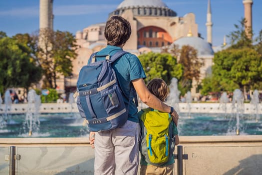 Father and son Tourists enjoy beautiful view on Hagia Sophia Cathedral, famous islamic Landmark mosque, Travel to Istanbul, Turkey. Traveling with kids concept. Sunny day architecture and Hagia Sophia Museum, in Eminonu, istanbul, Turkey. Turkiye.
