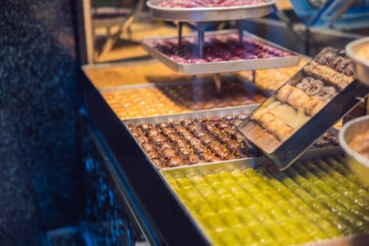 Traditional oriental sweet pastry cookies, nuts, dried fruits, pastilles, marmalade, Turkish desert with sugar, honey and pistachio, in display at a street food market.