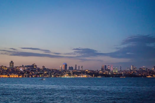 Istanbul at sunset, Turkey. Tourist boat sails on Golden Horn in summer. Beautiful sunny view of Istanbul waterfront with old mosque. Concept of travel, tourism and vacation in Istanbul and Turkey. Turkiye.