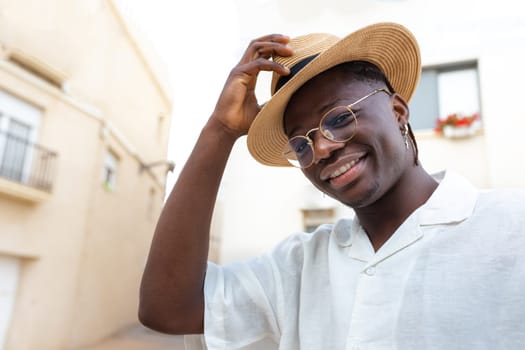 Young African American man wearing a hat on vacations looking at camera. Lifestyle concept.