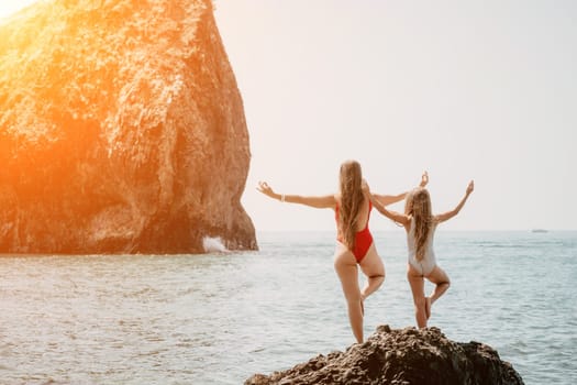 Silhouette mother and daughter doing yoga at beach. Woman on yoga mat in beach meditation, mental health training or mind wellness by ocean, sea