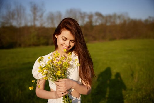 portrait of a happy woman with a bouquet of buttercups walking in the field. High quality photo