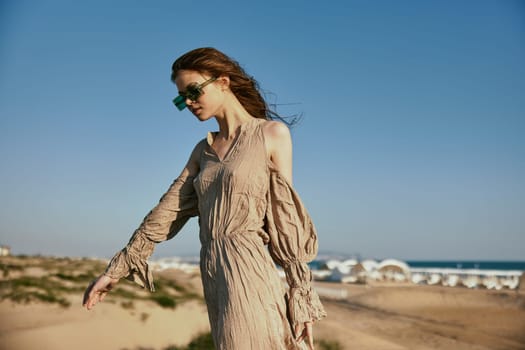 horizontal portrait of a slim woman in sunglasses against a blue sky. High quality photo