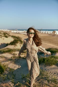 stylish woman, in summer, walks on the coast in windy weather enjoying vacation. High quality photo