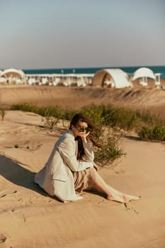 a woman on the beach sits in a stylish jacket during her vacation. High quality photo