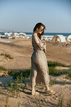 stylish woman, in summer, walks on the coast in windy weather enjoying vacation. High quality photo