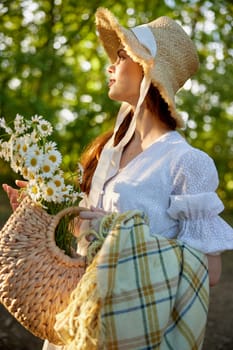 close portrait of a beautiful woman in a wicker hat and with a plaid in her hands holding a basket of daisies. High quality photo