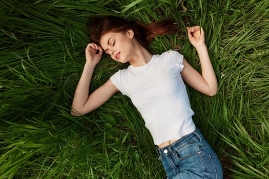 The young woman lies in a green bright grass i. High quality photo