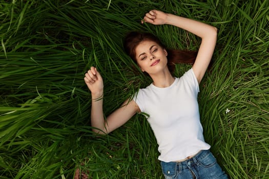 Happy woman resting and day lying down on green grass. High quality photo