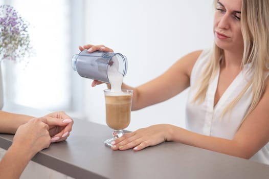 Receptionist in a beauty salon prepares coffee for a client