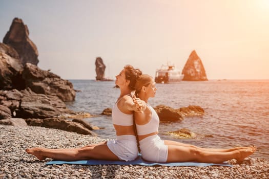 Woman sea yoga. Back view of free calm happy satisfied woman with long hair standing on top rock with yoga position against of sky by the sea. Healthy lifestyle outdoors in nature, fitness concept.