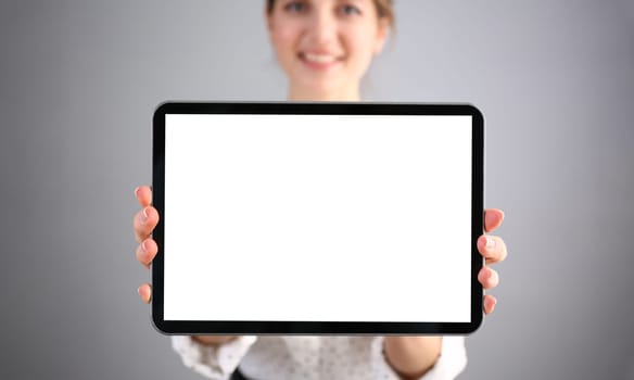 Beautiful smiling businesswoman is holding digital tablet. Advertising bpnner on tablet screen