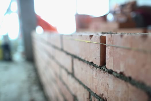 Brickwork of the wall correct laying of red brick for reliable wall of strong house or brick building. Construction concept.