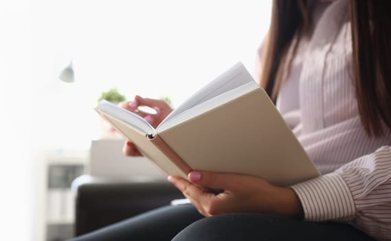 Closeup of female author writing notes in journal at home. Writer writes new script at home