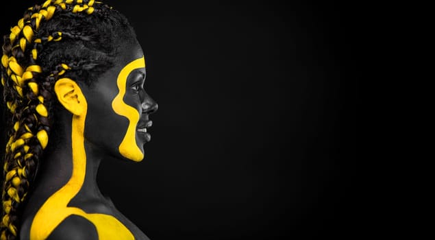 The Art Face. Black and yellow body paint on african woman. Abstract creative portrait. Copy space for your text.