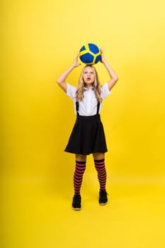 Portrait of cute eight year old girl in volleyball outfit isolated on a red yellow background