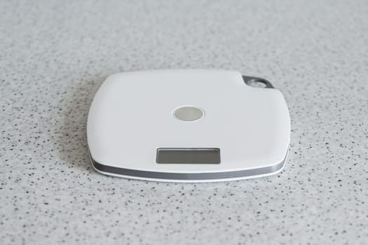Digital kitchen scale on a kitchen table. Electronic scales for measurement the food weight, copy space.