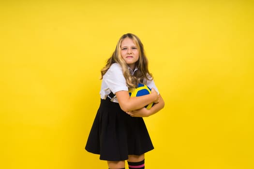 Portrait of cute eight year old girl in volleyball outfit isolated on a red yellow background