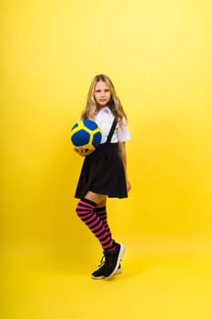 Portrait of cute eight year old girl in volleyball outfit isolated on a red yellow background