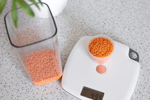 Cooking lentil soup puree starts by weighing the exact weight of the lentils on a kitchen scale. Cooking background for lentil soup recipe, copy space.