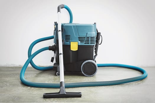 Powerful construction vacuum cleaner in an empty room after renovation.