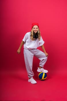 Portrait of cute eight year old girl in volleyball outfit isolated on a red yellow background