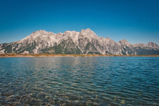 Asitz mountain in the background of the pure and calm lake, Austria