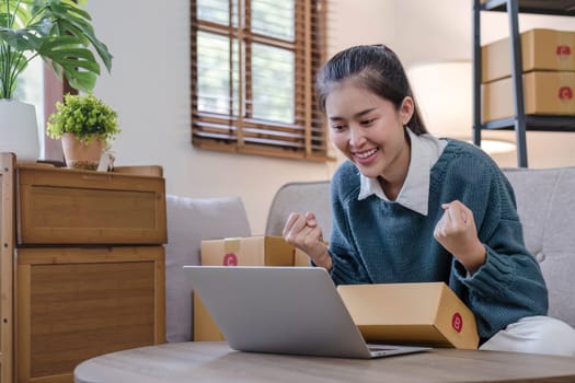 Portrait young attractive asian female owner startup business work happy with box at home prepare parcel delivery in sme supply chain, start up small business concept...