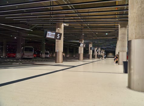An empty bus station inside with parked buses and large columns. High quality photo