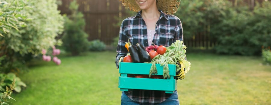 farmer carrying box of picked vegetables