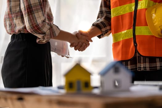 successful team engineers and business partner shaking hand, engineer and architecture shaking hand after finish an agreement, professional engineer plan to build a house. High quality photo