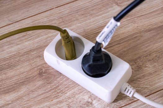 Extension cord with two sockets on the floor close up