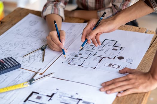 engineer are helping to design work on blueprints, engineer people meeting working and pointing at a paper, professional engineer and architect are drafting a constuction house room building. High quality photo
