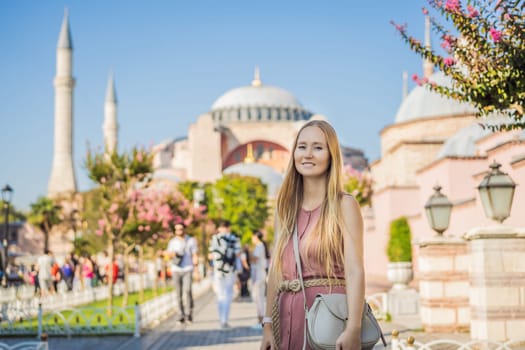 Woman enjoy beautiful view on Hagia Sophia Cathedral, famous islamic Landmark mosque, Travel to Istanbul, Turkey. Sunny day architecture and Hagia Sophia Museum, in Eminonu, istanbul, Turkey. Turkiye.