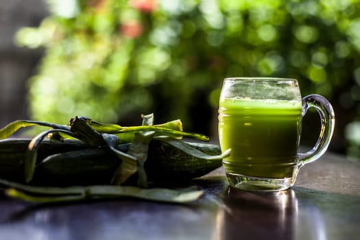Fresh juice of luffa or Galka or sponge gourd vegetable in a glass on the black surface.