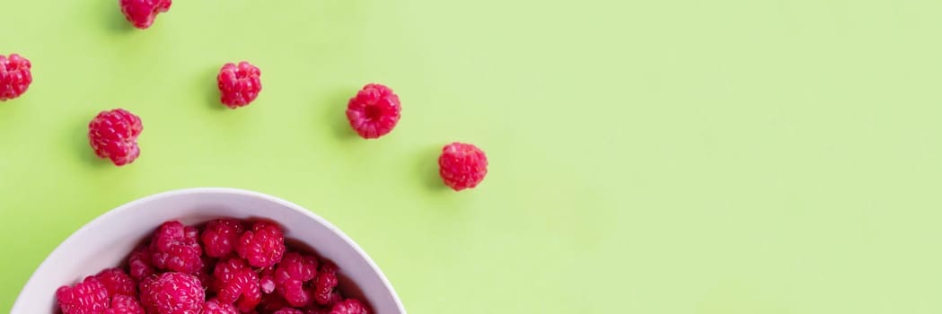 Red raspberry berry in plate on stone table. Fruit berries background. Summer food background.