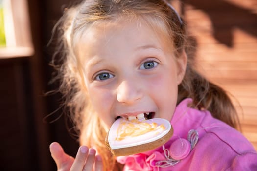 smiling teen girl eat oatmeal cookies on orange background