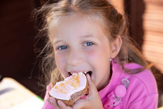 smiling teen girl eat oatmeal cookies on orange background