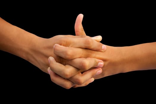 Shot of a human hand showing Linga mudra with interlocked fingers and thumb coming out of it isolated on black background.