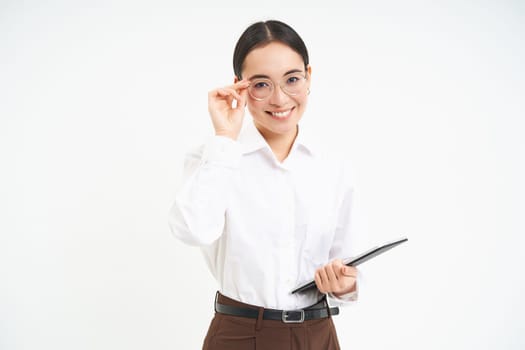 Asian woman professional, businesswoman in glasses, holding digital tablet, standing confident against white background.